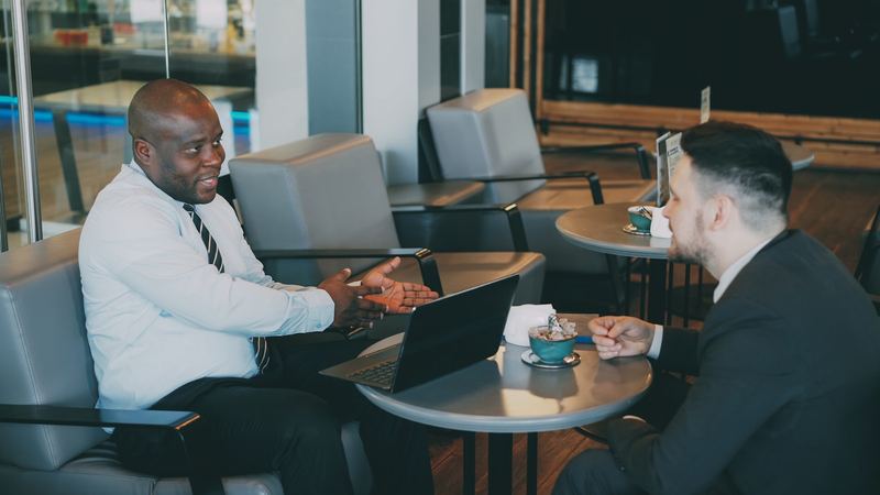 Two business partners talking through plans at a table